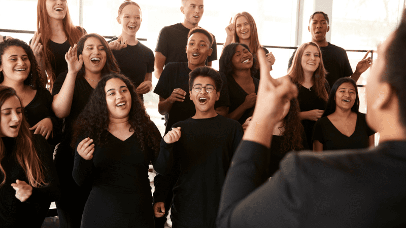 A school choir dressed all in black sings