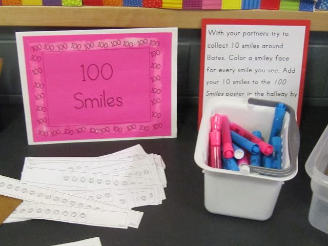قطعة ورقية زهرية زاهية عليها 100 ابتسامة مطبوعة عليها بجانب حوض به علامات ملونة