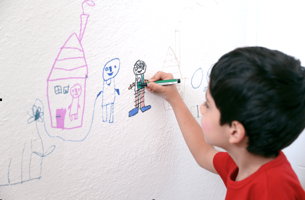 Child writing on walls in classroom Child writing on walls in classroom