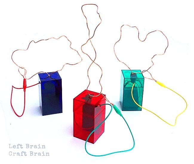 Colorful acrylic boxes with wire shapes attached to the tops and electrical wiring