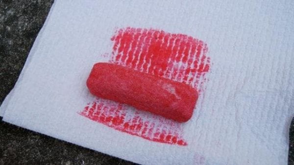 Pink sidewalk chalk stick sitting on a paper towel