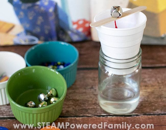 Several small bowls next to a water clock made from a jar of water, styrofoam cup, wood craft stock, and jingle bell (Seventh Grade Science)