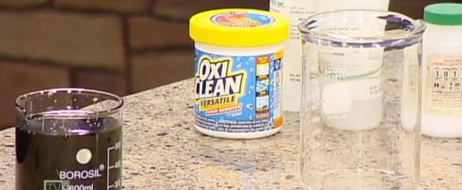 Container of OxiClean with beakers of liquid on a counter (Eighth Grade Science)