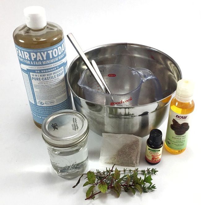 Mixing bowl with castille soap, jar of water, essential oils, and herbs