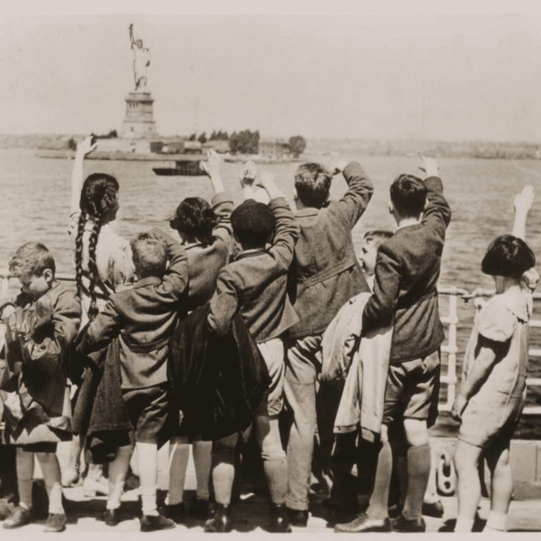 Photograph of Jewish refugee children wave at the Statue of Liberty as the SS President Harding Steams into New York harbor in 1939. 