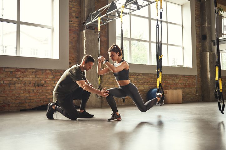 male trainer working with female client in gym, as an example of interactive career exploration activities