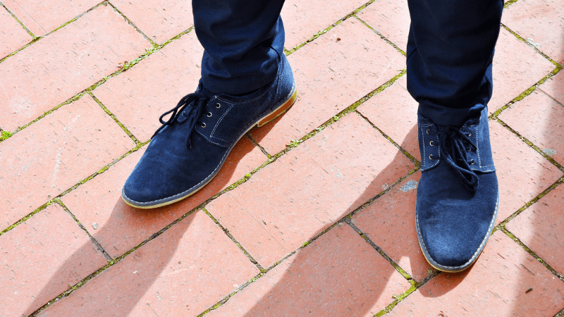 Blue Suede men's shoes on boardwalk - stock photo