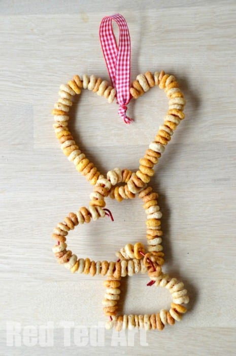 Un comedero para pájaros en forma de corazón hecho de Cheerios.