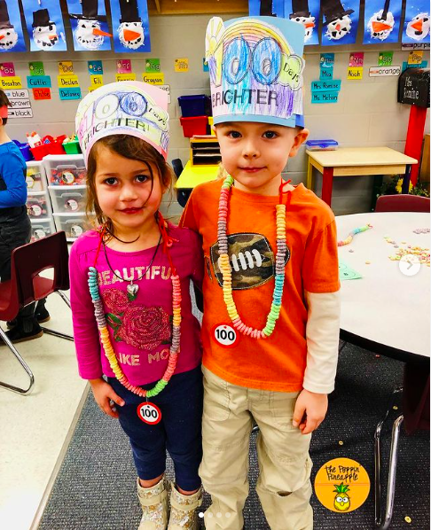 two students wearing 100th day cheerio necklaces