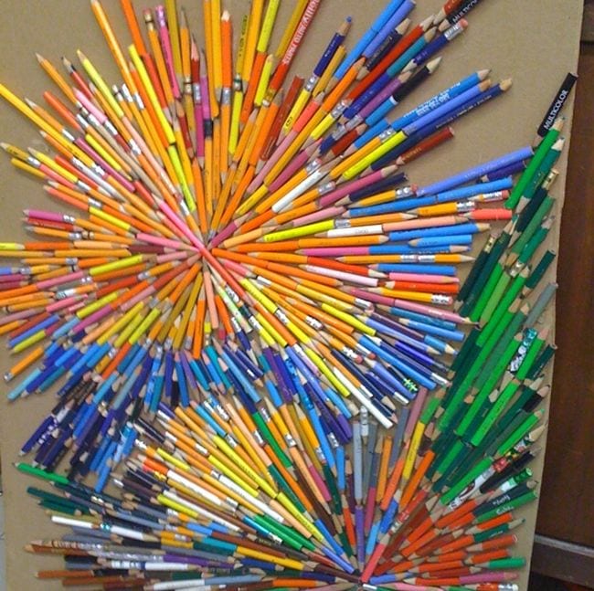 Broken and used colored pencils arranged into a starburst pattern