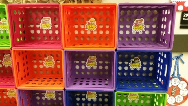 Colorful plastic crates stacked into cubbies and labeled with student names