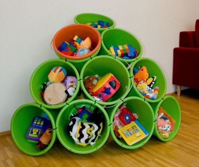 Green plastic tubs stacked into a pyramid and held together with zip ties, filled with toys and games