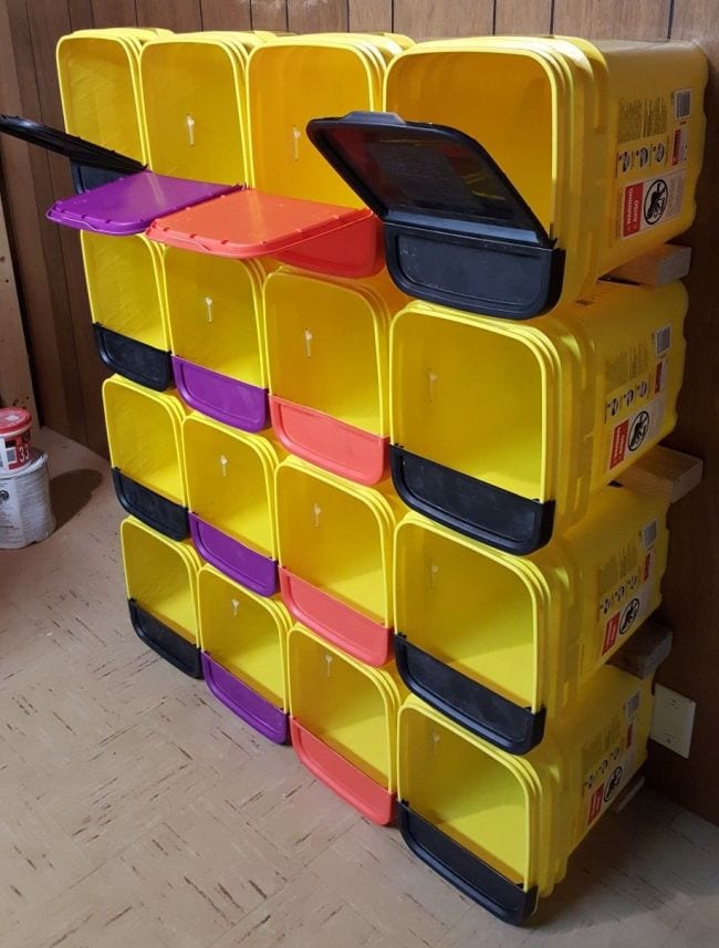 Square plastic cat litter containers stacked to form rows of cubbies