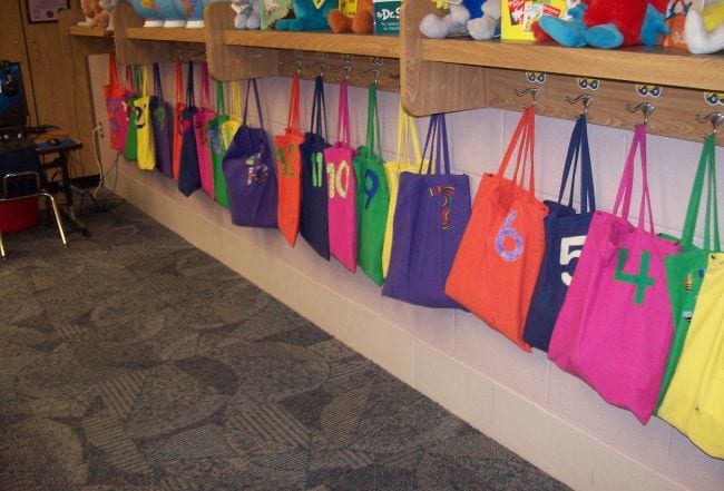 Kancalara asılan ve sınıf deposu olarak kullanılan renkli numaralı bez çantalar