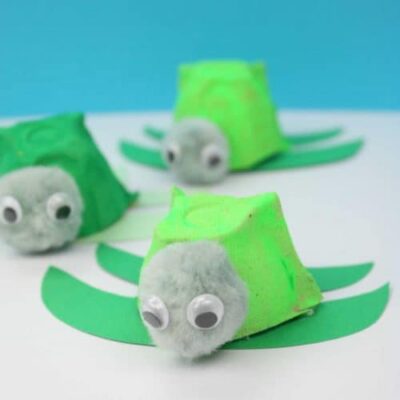 tiny baby turtles made from one section of an egg carton painted green, with green construction paper flippers and googly eyes on its face