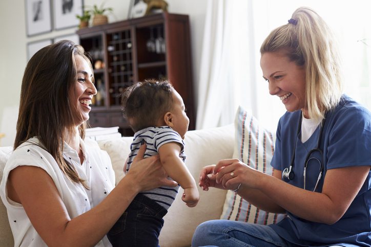 young female nurse examines a baby that mother is holding, , as an example of interactive career exploration activities