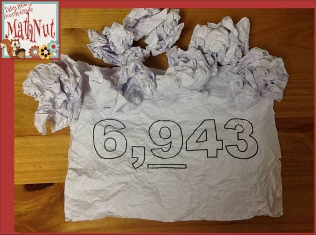 Crumpled pieces of paper, with one opened to show the number 6,943