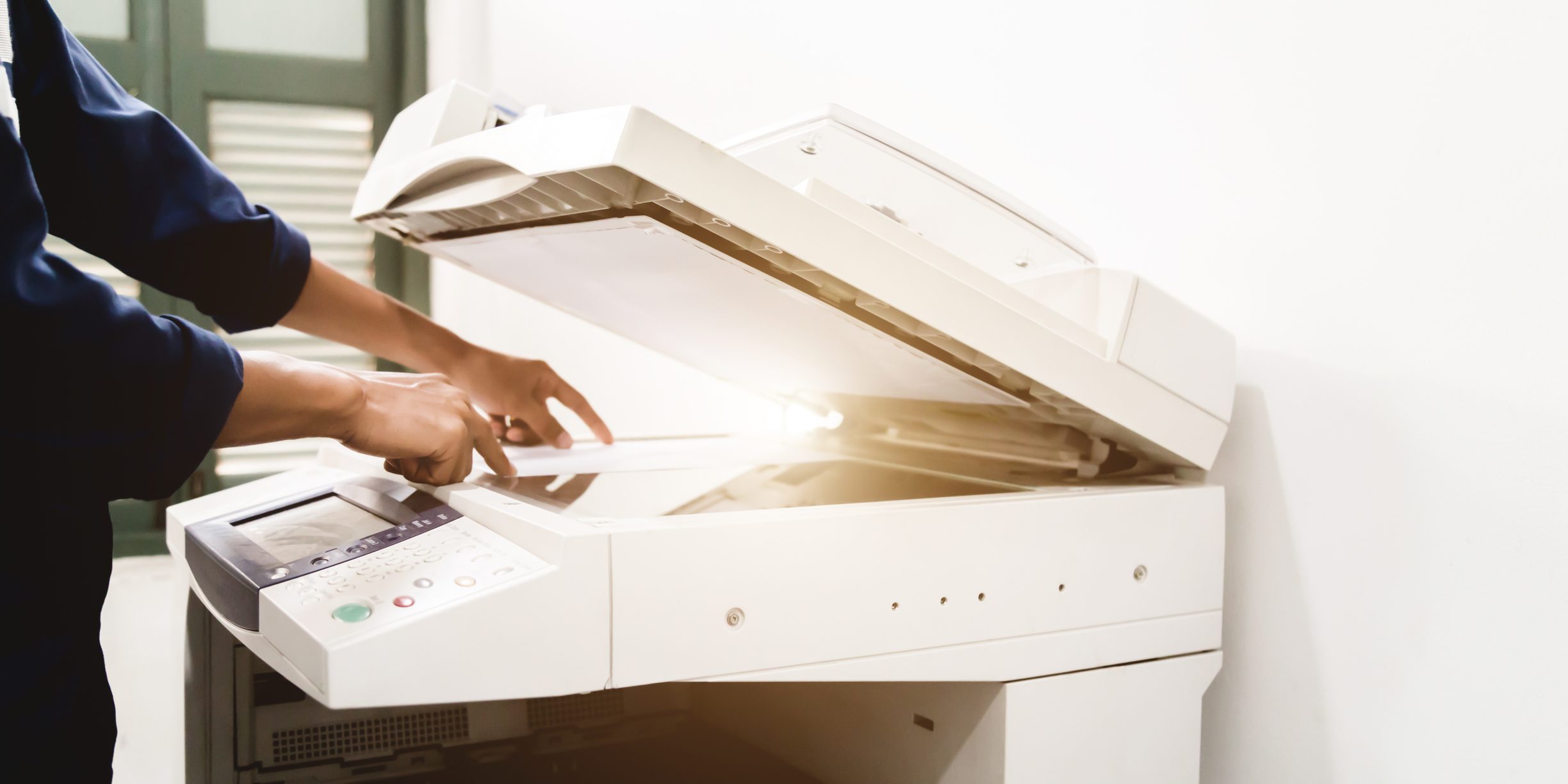 Bir kişinin elleri kullanılarak gösterilen bir fotokopi makinesinin fotoğrafı