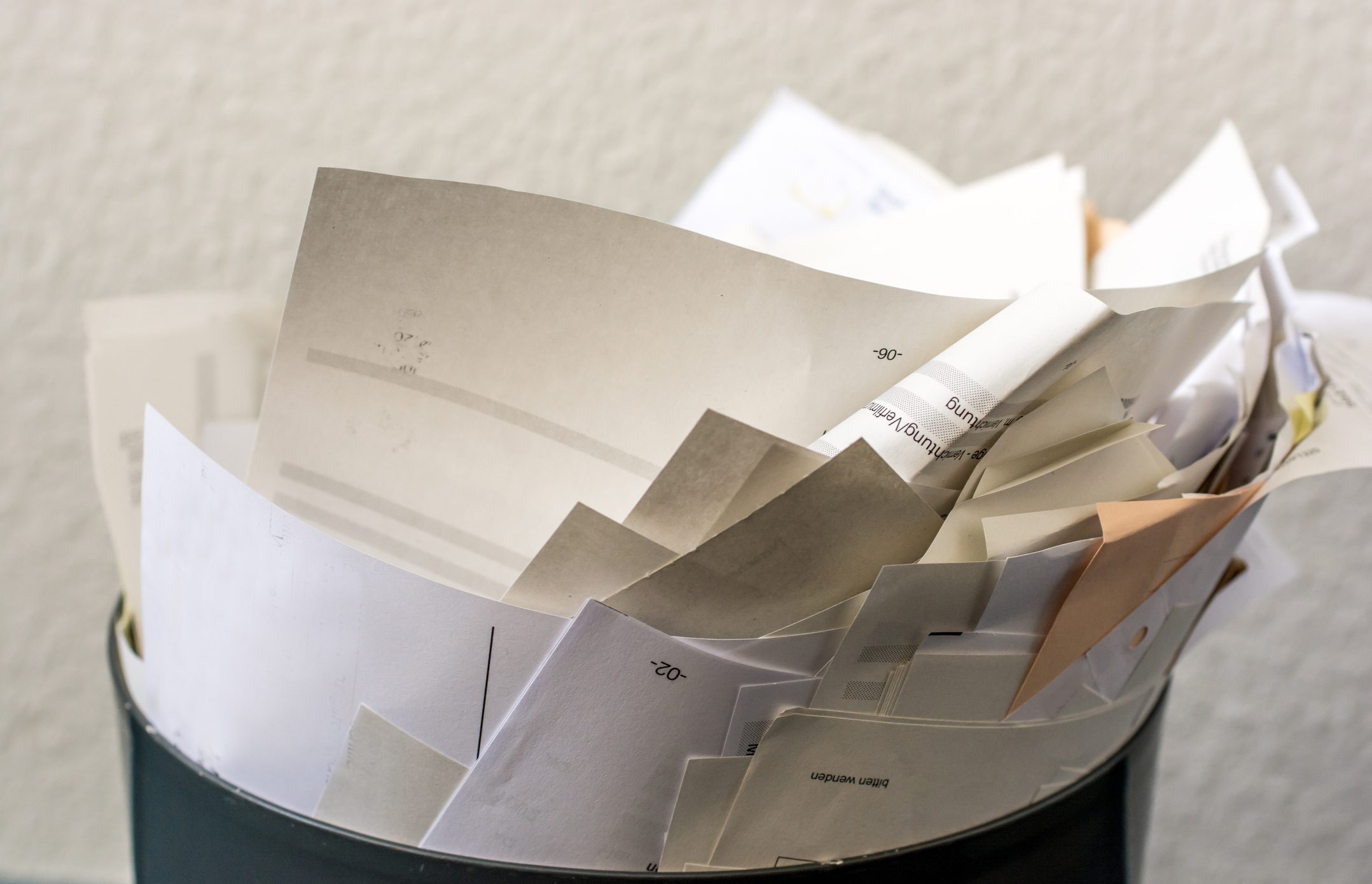 Photo of a trashcan over-filled with paper
