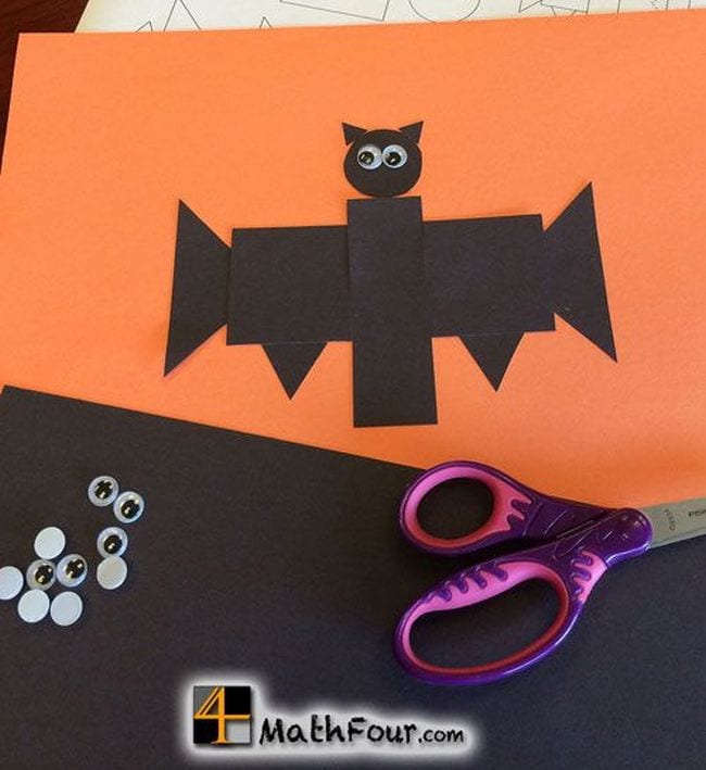 Construction paper bat made of geometric shapes with googly eyes and scissors