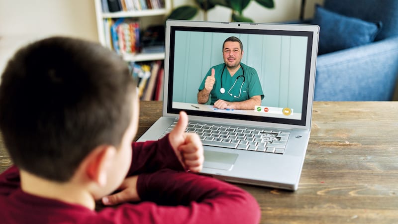Cute child talking with doctor on video call. There is good news from doctor. Family is happy.