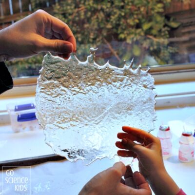 child's hands holding up a sheet of ice