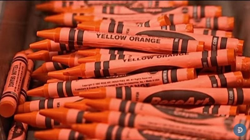 A pile of yellow orange crayons.