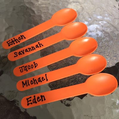 Orange spoons display student names for lunch time classroom planning
