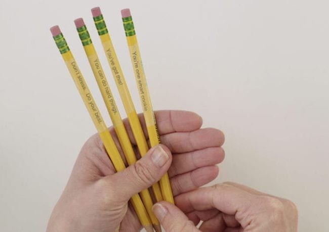 Teacher holding pencils personalized with a printer and clear tape