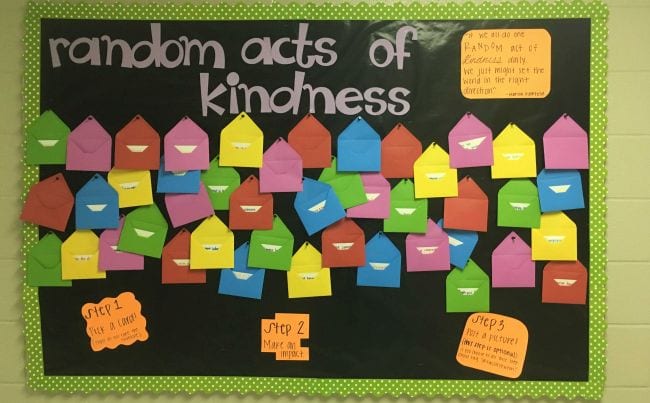 Random Acts of Kindness bulletin board with colorful envelopes pinned to it
