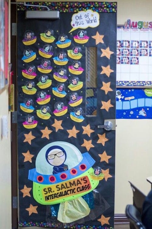 Classroom door decorated with teacher and students in small spaceships