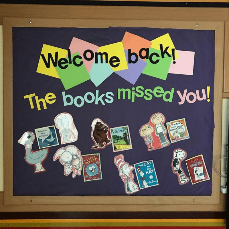 Bulletin board with pictures of books and book characters. Text reads "Welcome back! The books missed you!"
