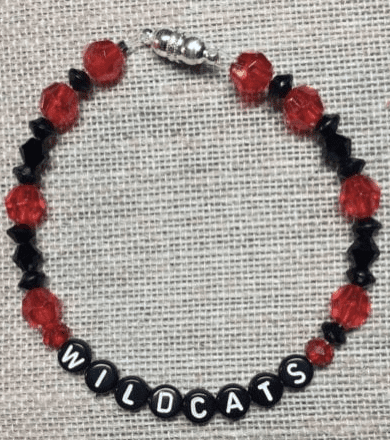 A black and red bracelet with a school spirit message on it