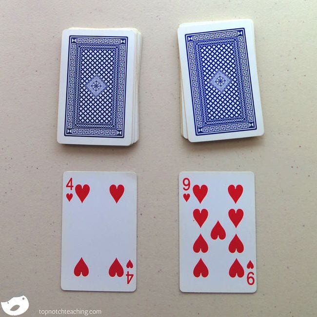 Two decks of cards with two cards laying face up (Math Card Games)
