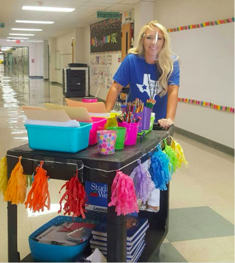 Teacher pushing brightly decorated portable supply cart 