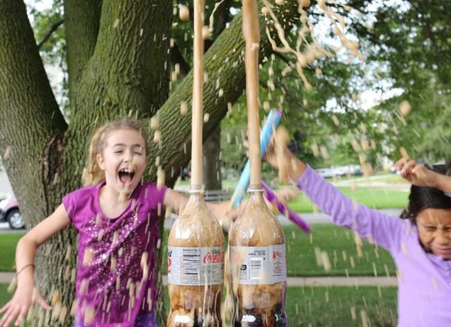 Students running away as foam explodes from soda bottles (Outdoor Science)