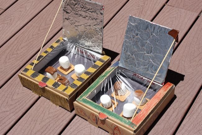 Solar ovens built from pizza boxes with s'mores cooking inside