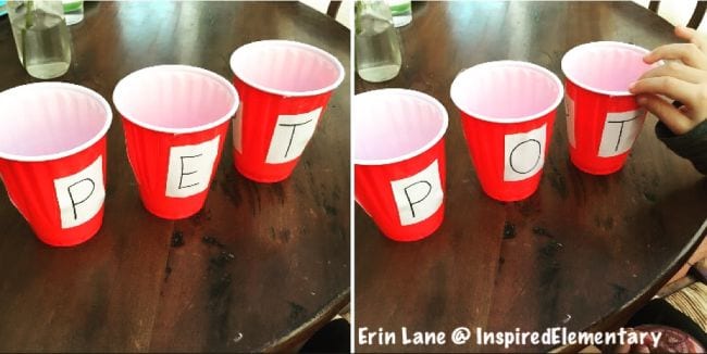 Child using red plastic cups labeled with letters to spell out simple words