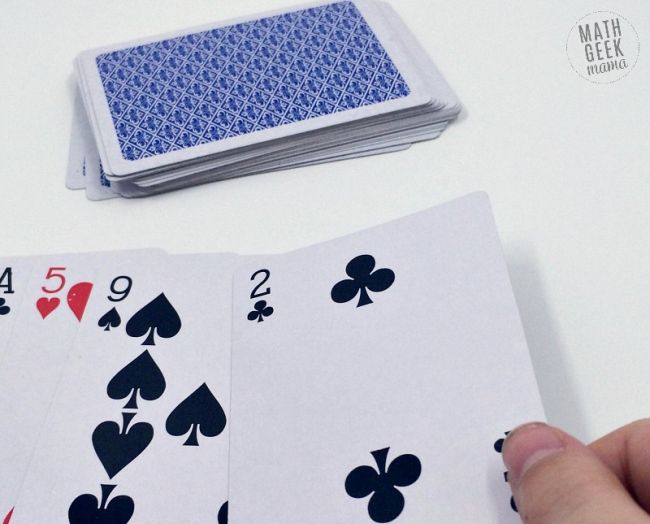 Pilha de cartas de jogo com quatro cartas viradas para cima numa mesa para actividades do dia pi para a sala de aula