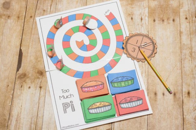 Pi Day printable board game with multicolored game spaces arranged in a spiral, a homemade spinner and four stacks of colored pie cards