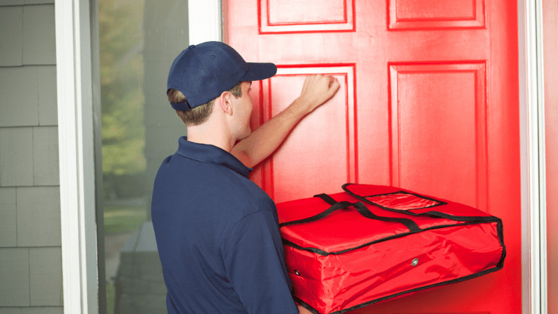 Pizza Delivery Man Delivering Food Package to Customer's Door Hz - stock photo