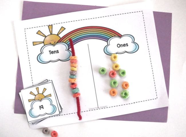 List s rainbow a mraky na každém konci, označené jako jedničky a desítky, s vytěrákem navlečené s Froot Loops a hrst volné obilovin