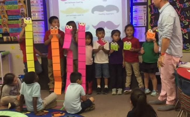 Kindergarten students holding large paper base ten blocks to represent the number 44 (Place Value Activities)