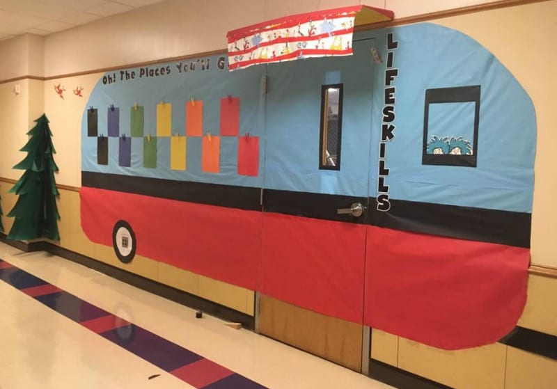 The Places You'll Go hallway decoration. Large camper made out of paper surrounding a classroom door, with a Dr. Seuss theme.