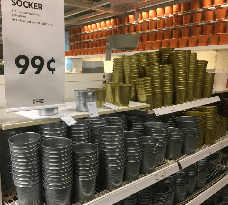 silver and gold galvanized pots displayed on a rack for 99 cents