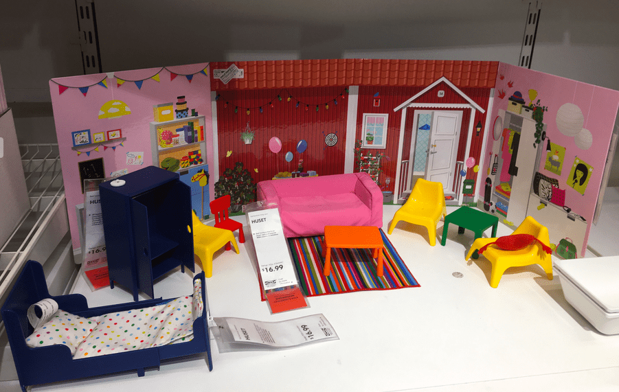 plastic dollhouse furniture in front of a colorful backdrop