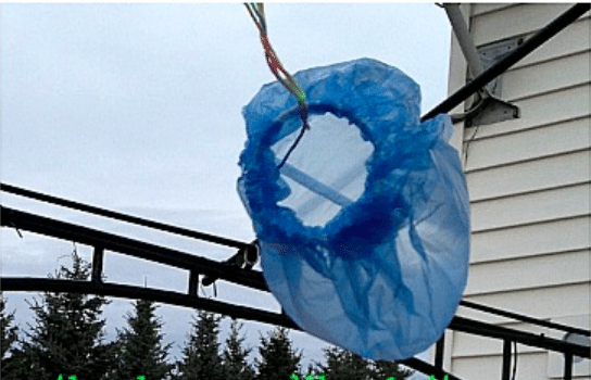 a homemade wind sock made from a blue plastic bag suspended by rope