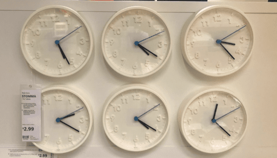 6 white plastic clocks displayed on a white wall