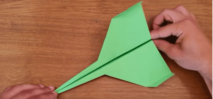 Hands making a paper airplane.