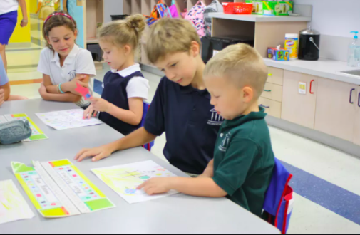 young students reading with buddies from an older class